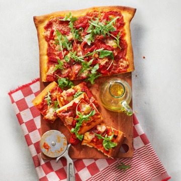 Pizza met rauwe ham en geroosterde paprika