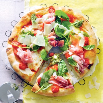 Verse pizza met tomaatjes, parmaham en spinaziepesto